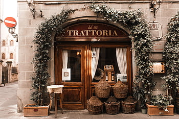 Cozy trattoria entrance with wicker baskets and ivy in Florence, Italy, exudes authentic Italian charm. HD wallpaper