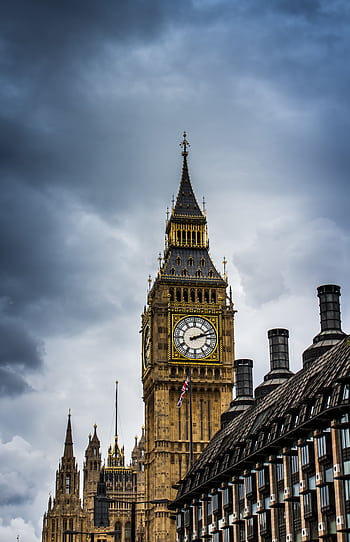 Stunning view of Big Ben in London with dramatic clouds overhead, showcasing iconic architecture. HD phone wallpaper