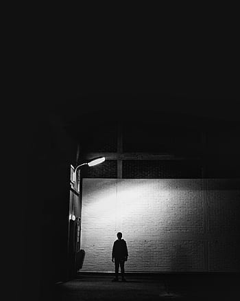 Silhouette of a person under a street lamp in an eerie urban alley at night. HD phone wallpaper