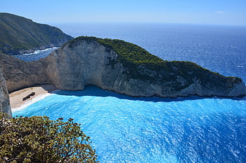 Breathtaking aerial shot of Navagio Beach's turquoise waters and limestone cliffs on Zakynthos Island. HD wallpaper