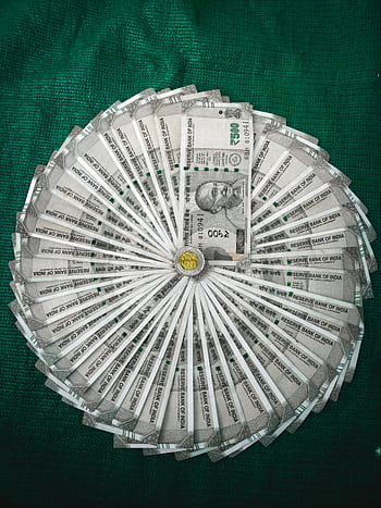 Top view of Indian Rupee notes arranged in a circular pattern on a green surface. HD phone wallpaper