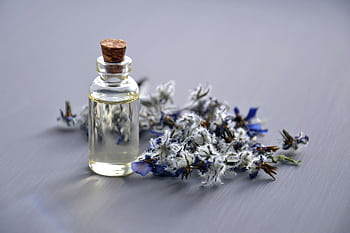 Close-up of a lavender oil bottle with dried flowers for aromatherapy. Perfect for wellness themes. HD wallpaper