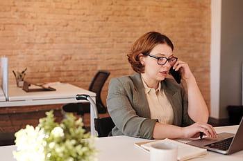 Professional woman in wheelchair working remotely on laptop and in a modern office. HD wallpaper