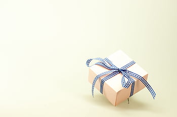 Pink gift box with blue ribbon on a soft background, perfect for celebrations and branding. HD wallpaper