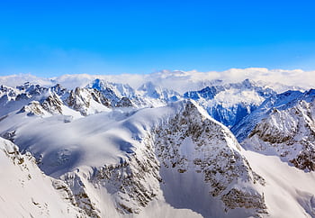 Breathtaking view of the snow-covered peaks in the Swiss Alps under a clear blue sky. HD wallpaper