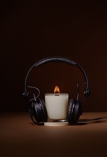 A peaceful moment with a candle and heads on a brown background, signifying relaxation and harmony. HD phone wallpaper