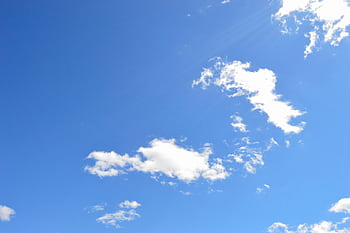 A clear blue sky with scattered white clouds on a bright day, perfect for backgrounds. HD wallpaper