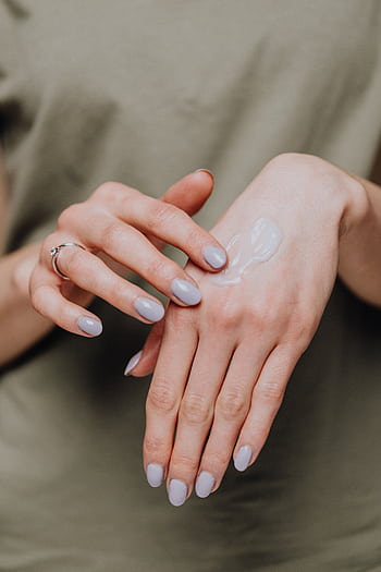 Close-up of female hands applying moisturizer cream for smooth skin care. HD phone wallpaper
