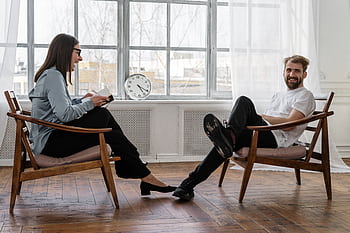 Counselor and client in a positive therapy session in a well-lit room. HD wallpaper