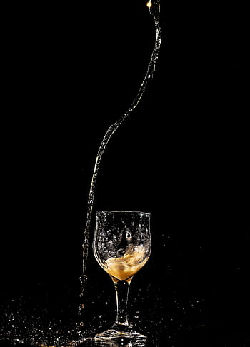 High-speed capture of liquid splash from a wine glass on a dark background. HD phone wallpaper