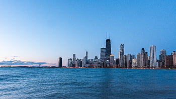 A stunning view of Chicago's skyline at twilight, captured from the waterfront with a clear blue sky. HD wallpaper