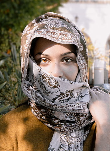 Close-up portrait of a woman wearing an ornate headscarf, showcasing her expressive eyes. HD phone wallpaper