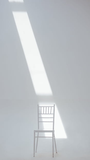 A white chair in a minimalistic setting with sunlight casting a dramatic shadow. HD phone wallpaper