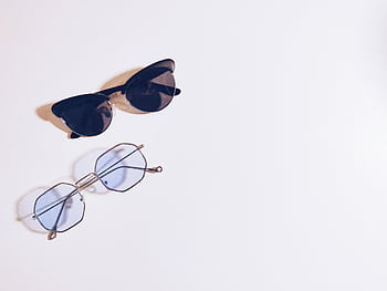 Flat lay of sunglasses and eyeglasses on a white background, perfect for fashion design concepts. HD wallpaper