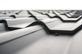 Close-up view of a metal roof's wavy design showcasing rivets and structural detail. HD wallpaper