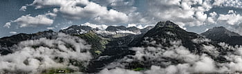 Panoramic view of a majestic mountain range with a cloudy sky, showcasing the beauty of nature. HD wallpaper