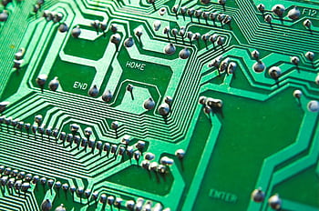 Detailed view of green circuit board with visible chips and pathways, highlighting technology elements. HD wallpaper