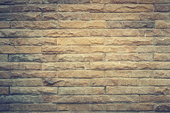 Rustic brown brick wall with textured pattern, perfect for backgrounds and design elements. HD wallpaper
