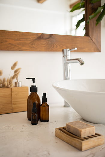 A serene bathroom scene featuring skincare products, a soap dish, and a stylish basin. HD phone wallpaper