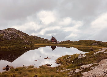 Serene mountain scene with a rustic cabin reflected in a lake near Bergen, Norway. HD wallpaper