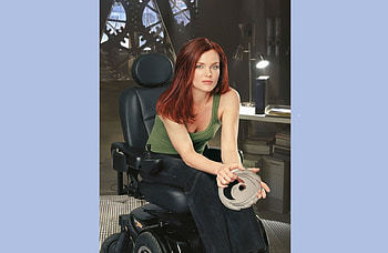 Dina Meyer as Barbara Gordon in Birds of prey, red head, sitting in wheel hair, holding tape, lamp HD wallpaper