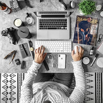 Overhead view of an organized desk with tech gadgets, fashion magazine, and accessories for modern working lifestyle. HD phone wallpaper