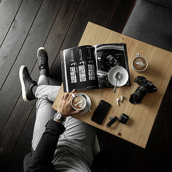 A stylish overhead view of a man enjoying coffee with gadgets on a wooden table. HD phone wallpaper