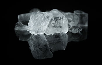 A detailed close-up of ice cubes reflecting on a dark surface, creating a cool ambiance. HD wallpaper