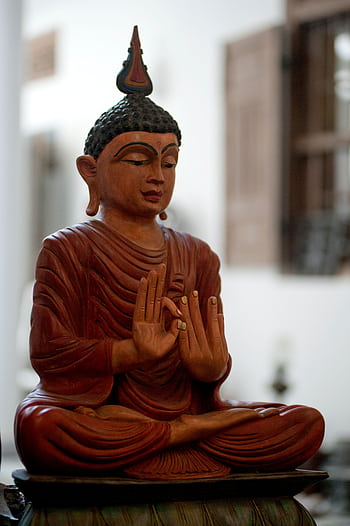 A peaceful wooden Buddha statue symbolizing tranquility and spirituality indoors. HD phone wallpaper