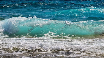 Captivating turquoise ocean waves crashing onto a sandy beach, evoking summer tranquility. HD wallpaper