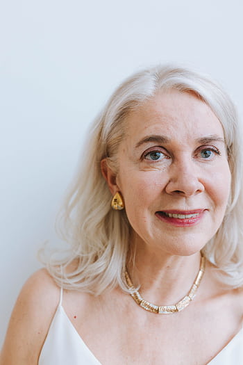 A smiling senior woman with earrings and necklace from a portrait session. HD phone wallpaper