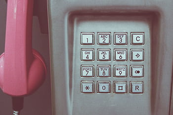 Close-up of a vintage pay keypad with pink receiver, highlighting retro technology. HD wallpaper