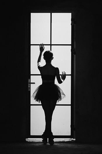 A graceful ballerina in silhouette poses against a glass door, embodying elegance and poise. HD phone wallpaper