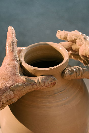 Close-up of hands molding a clay pot, highlighting the art of pottery making. HD phone wallpaper