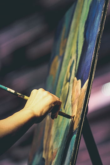 An artist's hand painting a vibrant abstract artwork on a canvas with a brush. HD phone wallpaper