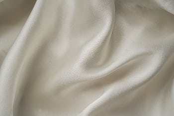 Close-up of smooth white silk fabric with soft folds and gentle draping. HD wallpaper