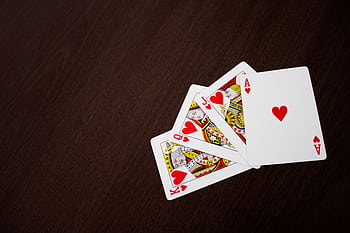 Elegant flat lay of playing cards featuring ace of hearts on a wooden surface. HD wallpaper