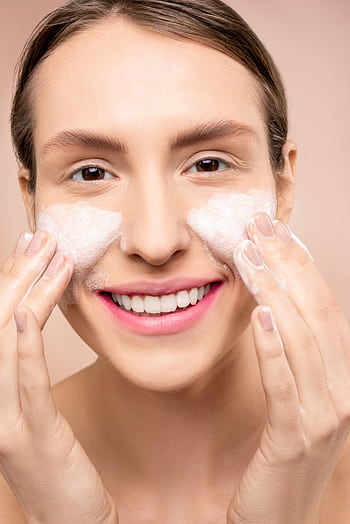 Close-up of a woman happily washing her face with foamy cleanser. HD phone wallpaper