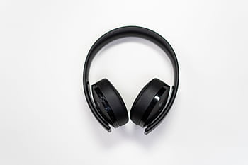Black over-ear heads placed on a white surface, perfect for tech and music themes. HD wallpaper