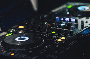A detailed shot of professional DJ equipment featuring knobs and LED lights, perfect for music events. HD wallpaper