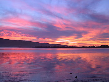 A stunning sunset over a serene lake with colorful sky reflections, ideal for nature themes. HD wallpaper