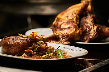 Close-up of a deliciously roasted chicken dish served with garnish, highlighting fine cuisine. HD wallpaper