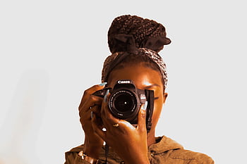 Portrait of a woman holding a DSLR camera with braided hair and bandana. HD wallpaper