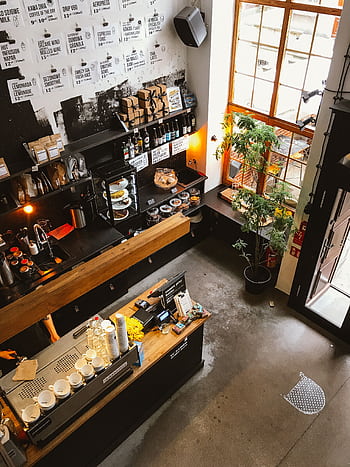 High angle view of a modern coffee shop interior with a wooden counter and cozy furnishings, ideal for business and leisure. HD phone wallpaper