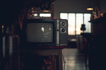 A classic CRT television in a dimly lit vintage room in Ho Chi Minh City, Vietnam. HD wallpaper