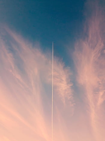 A scenic view of a dramatic sky with a single contrail, captured at sunset creating a serene atmosphere. HD phone wallpaper
