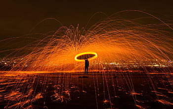 Captivating steel wool graphy with dramatic sparks lighting up the night sky. HD wallpaper