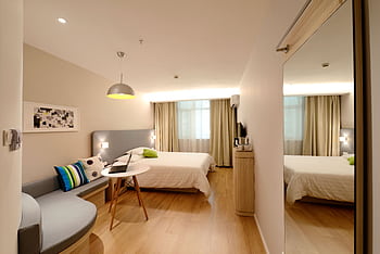 Spacious modern hotel room featuring cozy decor and neutral tones with natural light. HD wallpaper