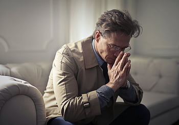 A thoughtful businessman sitting indoors, appearing contemplative and pensive. HD wallpaper