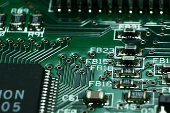 Detailed macro view of a circuit board showcasing microchips and electronic components. HD wallpaper